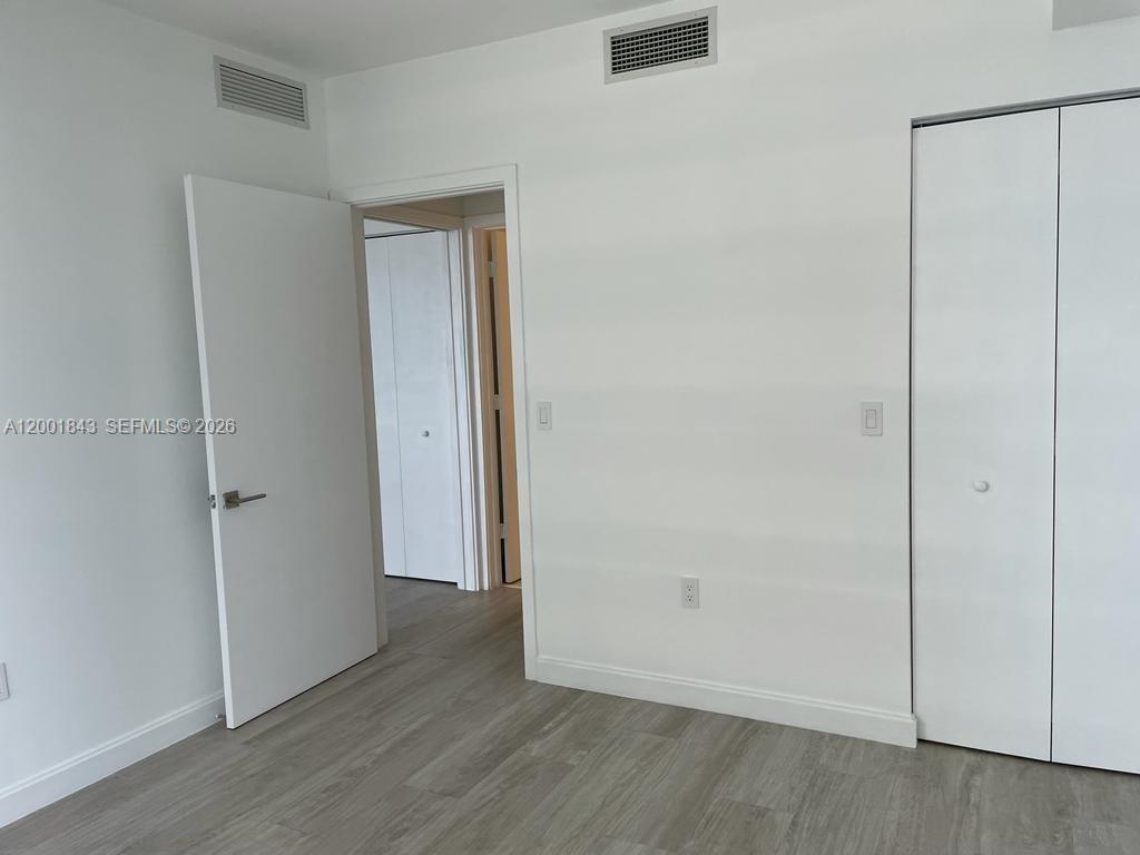 55 Southwest 9th Street, Unit 3102 Miami, FL 33130 - Photo 9 of 13 an empty room with wooden floor