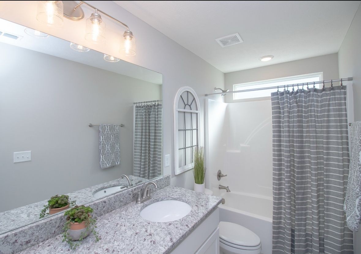 4216 Spyglass Drive Murfreesboro, TN 37127 - Photo 4 of 9 a bathroom with a granite countertop sink a mirror a toilet and shower