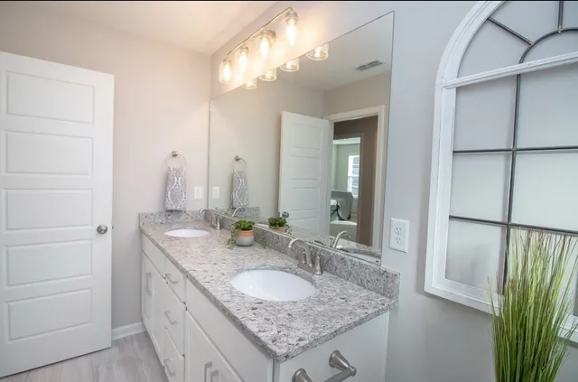 a bathroom with a granite countertop sink and a mirror