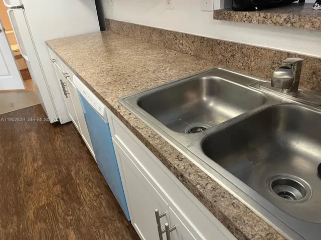a kitchen with granite countertop white cabinets and a stove