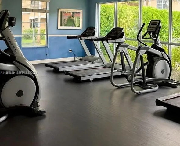 a view of a patio with table and chairs potted plants and palm trees