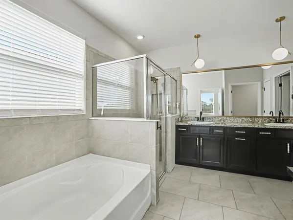 a bathroom with a granite countertop sink a mirror and a shower
