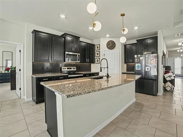 a large kitchen with stainless steel appliances granite countertop a stove and a sink