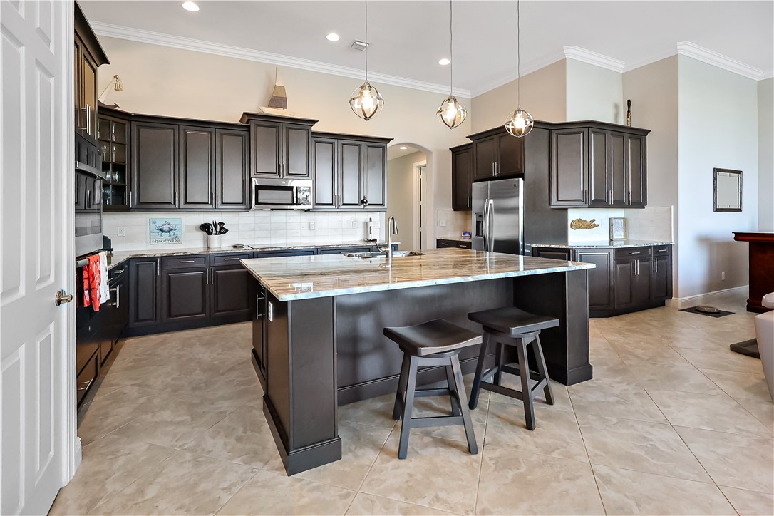 607 Yearling Trail Sebastian, FL 32958 - Photo 23 of 33 a kitchen with a sink a stove and chairs