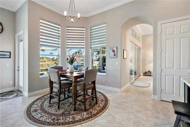 a dining room with furniture a chandelier and wooden floor