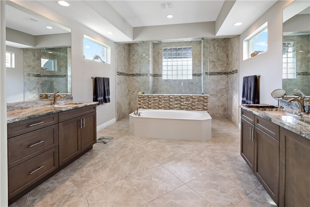 607 Yearling Trail Sebastian, FL 32958 - Photo 9 of 33 a spacious bathroom with a granite countertop sink a mirror and a bathtub