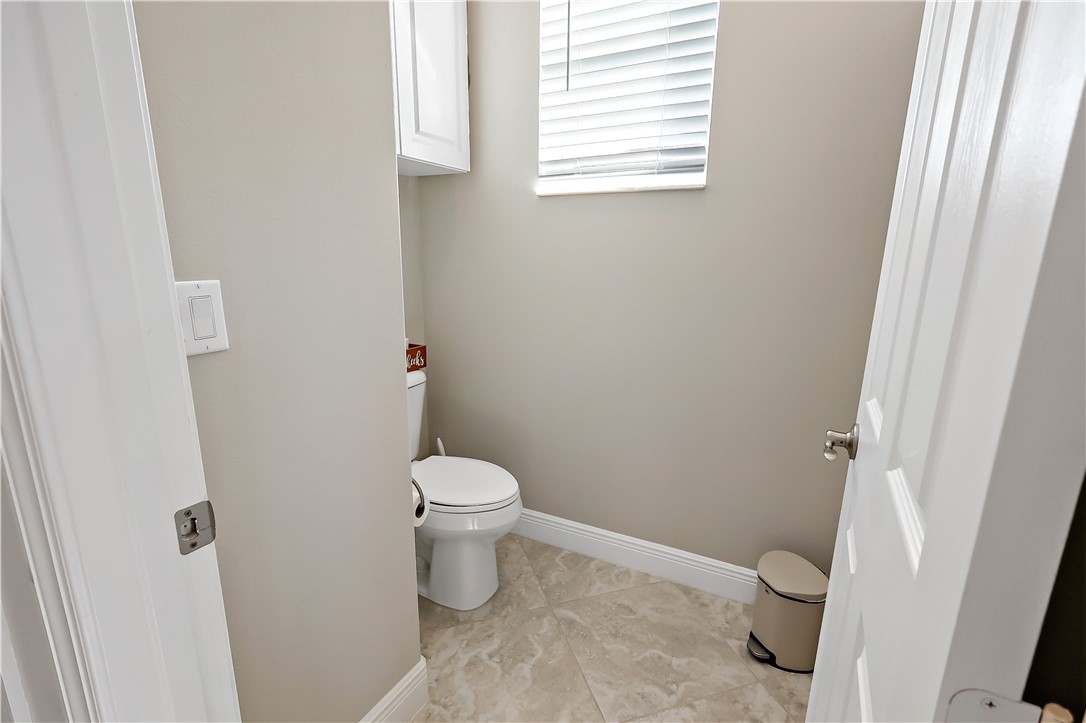 607 Yearling Trail Sebastian, FL 32958 - Photo 10 of 33 a white toilet sitting next to a bathroom sink and a vanity