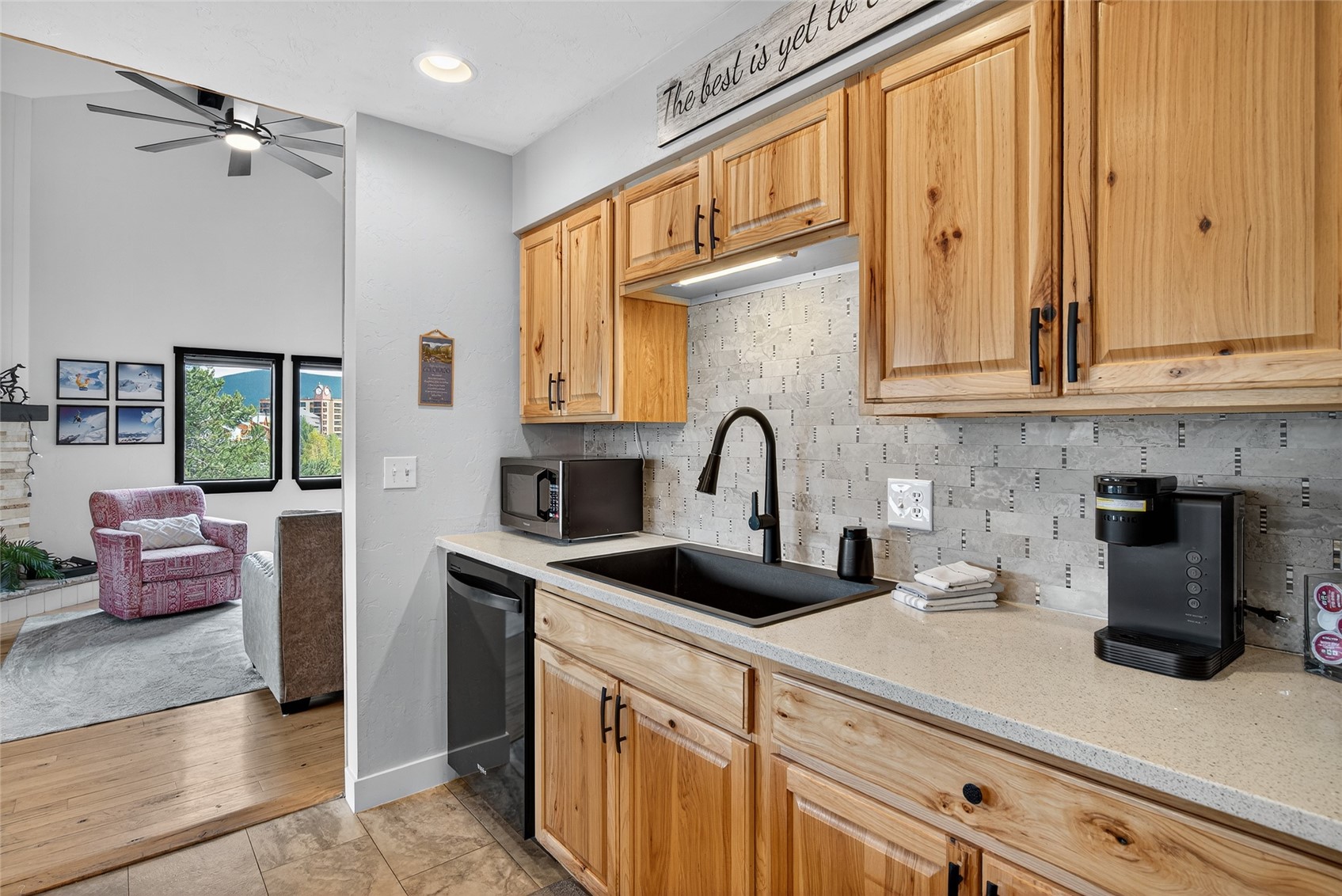 325 Four Oclock Road, Unit A301 Breckenridge, CO 80424 - Photo 41 of 41 Kitchen featuring decorative backsplash, light stone counters, stainless steel microwave, open floor plan, and black dishwasher