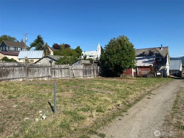 a view of a yard with wooden fence