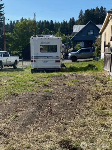 a view of a house with backyard and sitting area