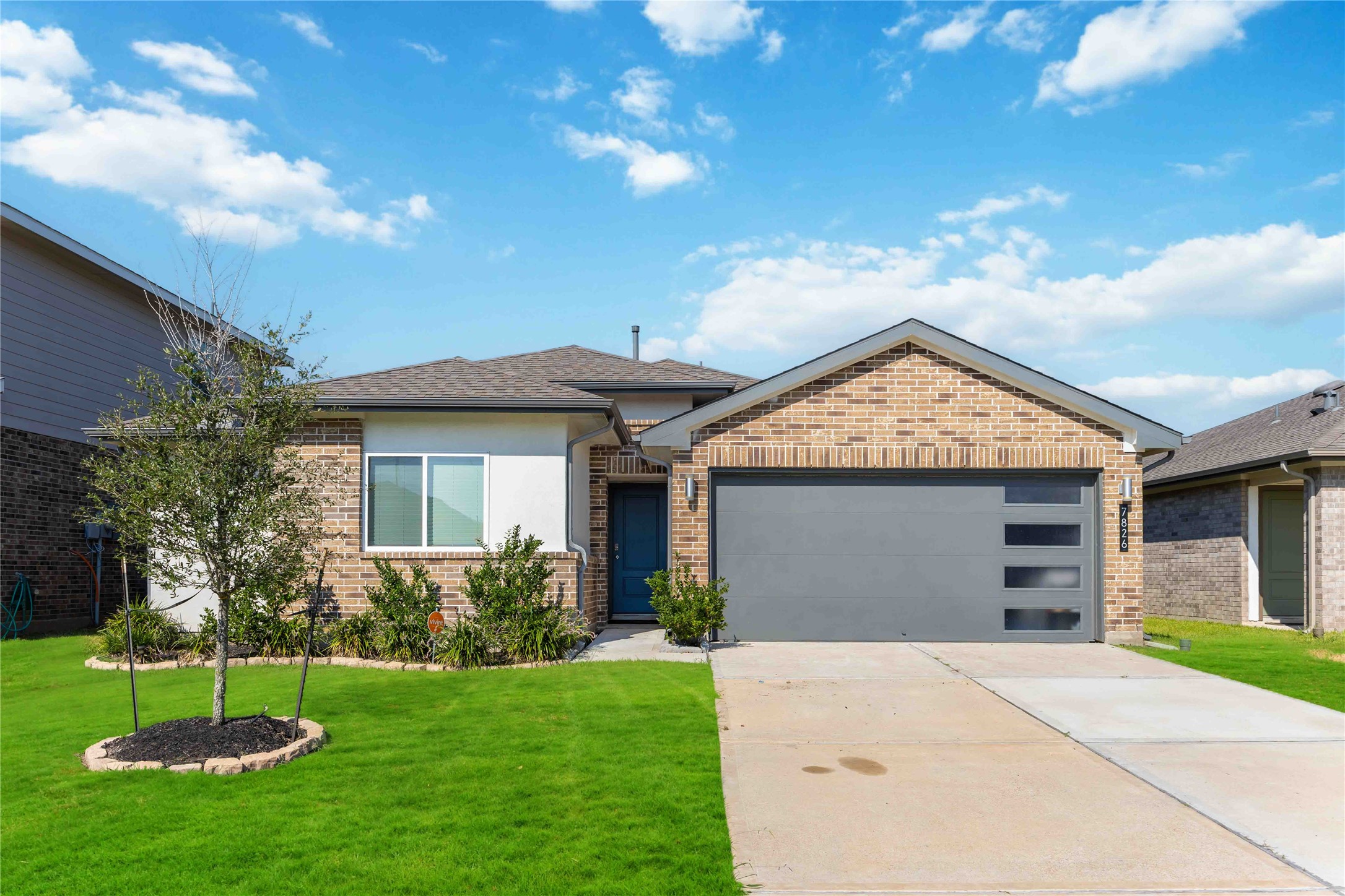 a front view of a house with a garden and yard