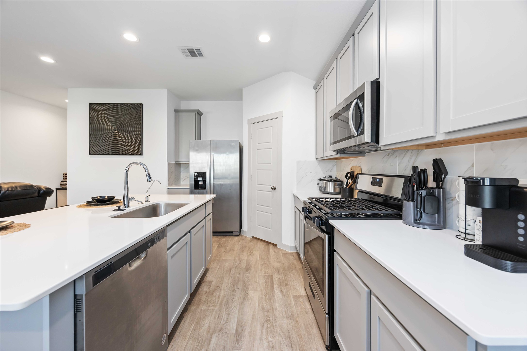 7826 Cattleman Vly Drive Rosharon, TX 77583 - Photo 12 of 29 a kitchen with stainless steel appliances granite countertop a sink a stove and a refrigerator
