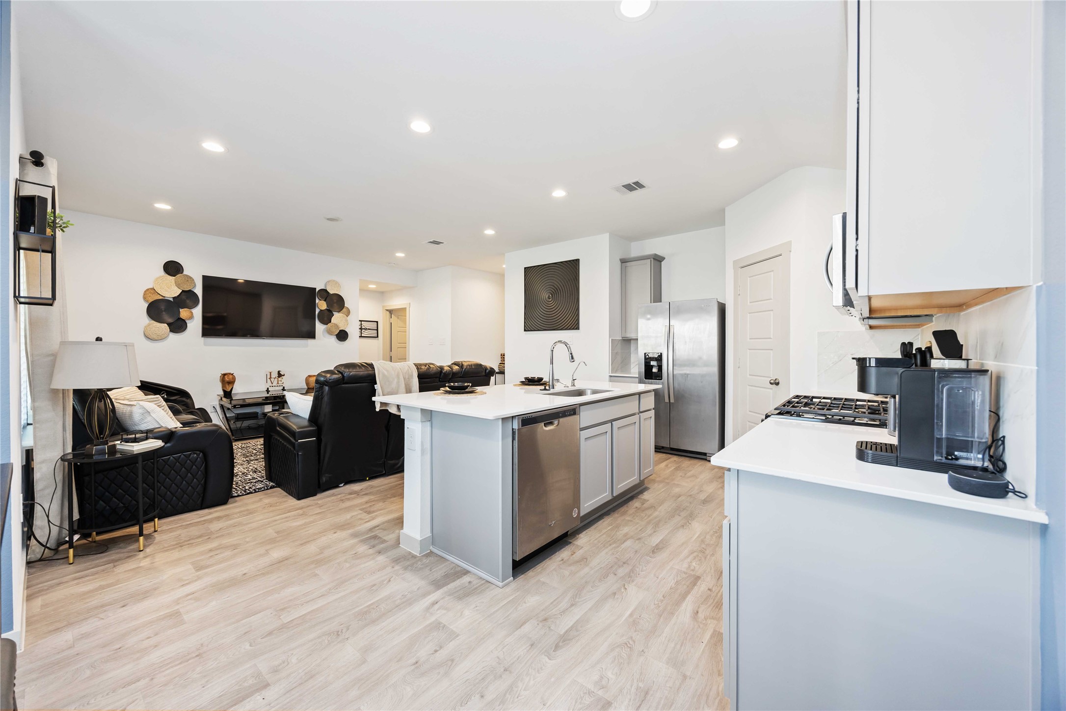 7826 Cattleman Vly Drive Rosharon, TX 77583 - Photo 8 of 29 a kitchen with stainless steel appliances kitchen island granite countertop a refrigerator oven a sink dishwasher and white cabinets with wooden floor