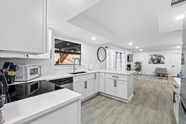 a kitchen with stainless steel appliances a stove a sink cabinets and a refrigerator