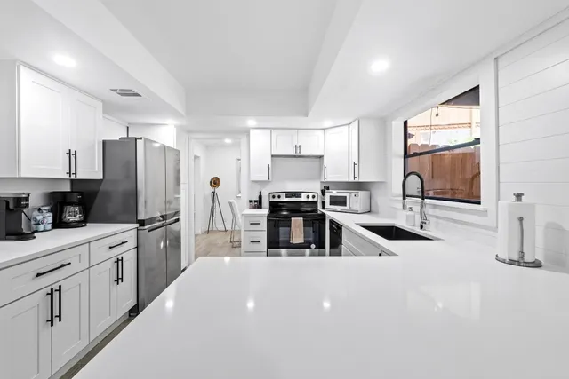 a kitchen with stainless steel appliances a refrigerator sink and cabinets