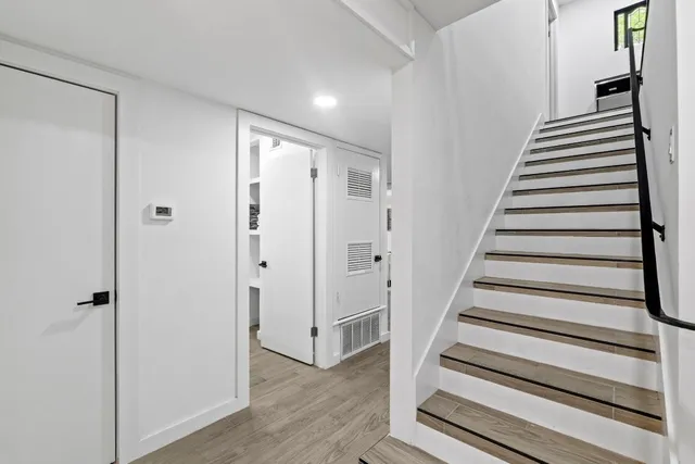 a view of a hallway with wooden floor and entryway