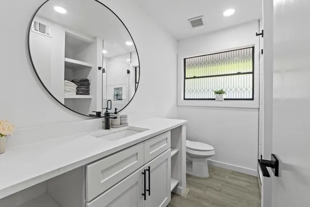 a view of bathroom with a toilet sink and mirror