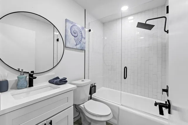 a bathroom with a sink a toilet and a mirror