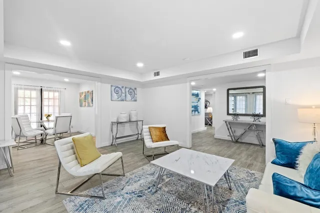 a living room with furniture and a wooden floor