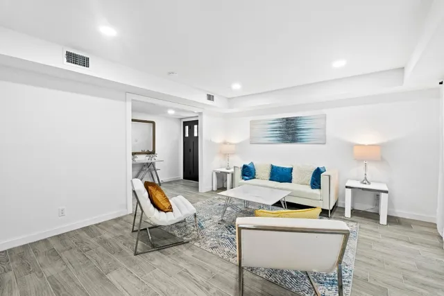 a living room with furniture a table and wooden floor