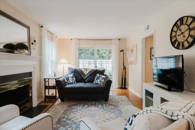 a living room with furniture a flat screen tv and a fireplace