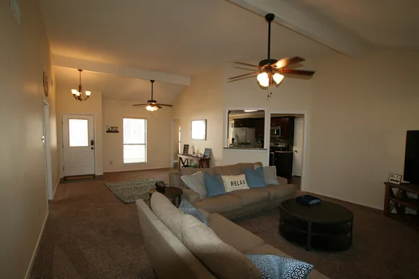 a living room with furniture a flat screen tv and a chandelier