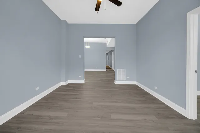 a view of a livingroom with wooden floor and a ceiling fan