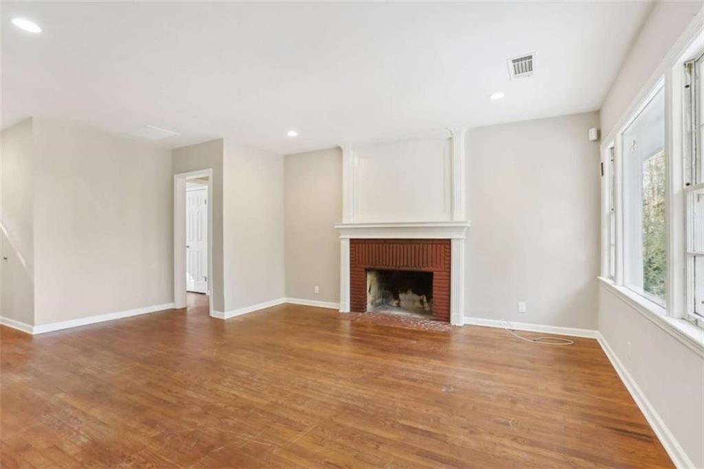 1840 Camellia Drive Decatur, GA 30032 - Photo 6 of 28 a view of an empty room with wooden floor fireplace and a window