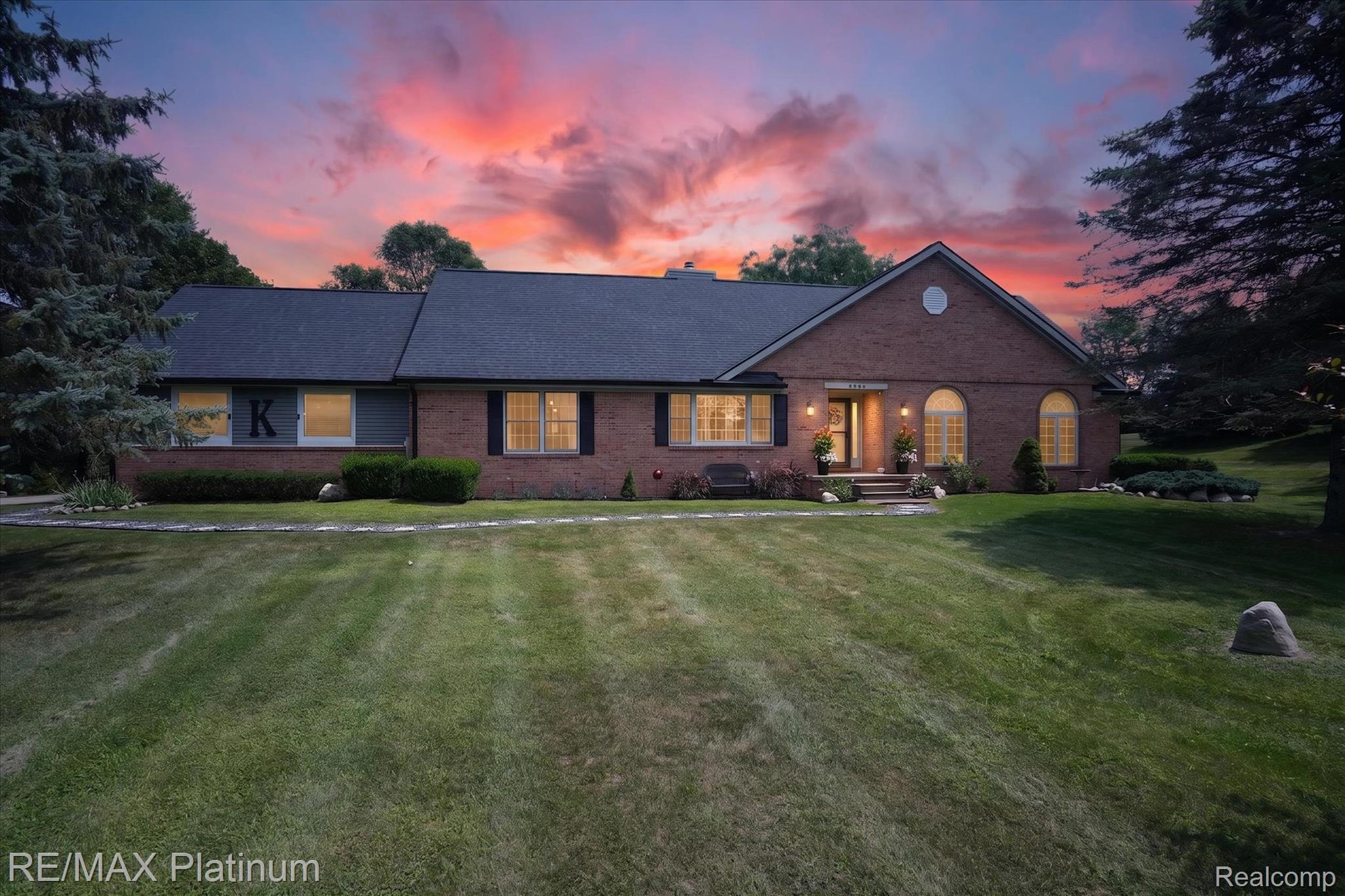 4457 Bradley Road Gregory, MI 48137 - Photo 65 of 79 Brick exterior with arched windows, mature landscaping, and a well-maintained lawn