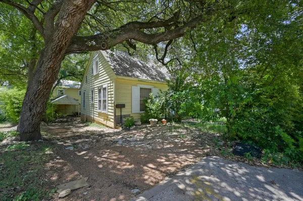 a view of a house with a tree in front of it