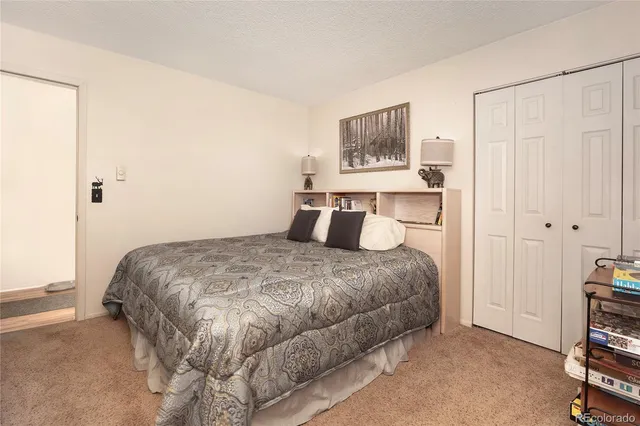 a bedroom with a bed and painting on the wall