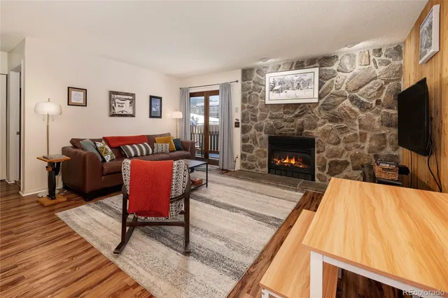 a living room with furniture a flat screen tv and a fireplace