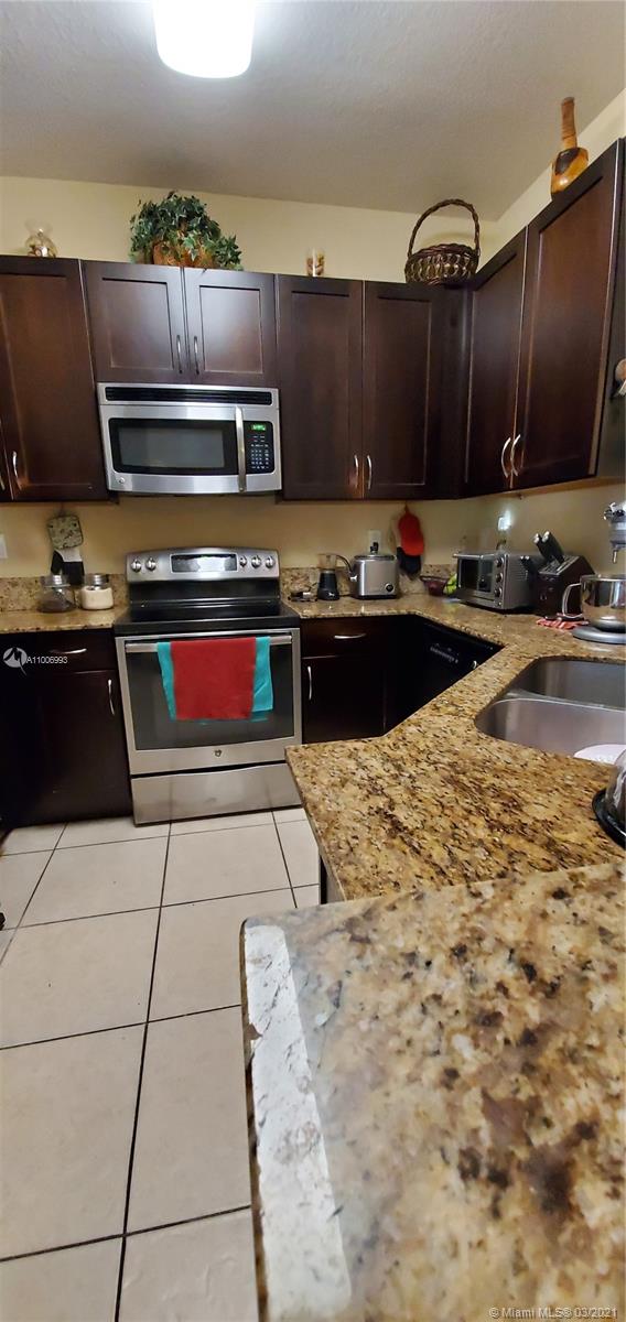14140 Southwest 275th Street, Unit 1 Homestead, FL 33032 - Photo 1 of 25 a kitchen with stainless steel appliances kitchen island granite countertop a stove and a sink