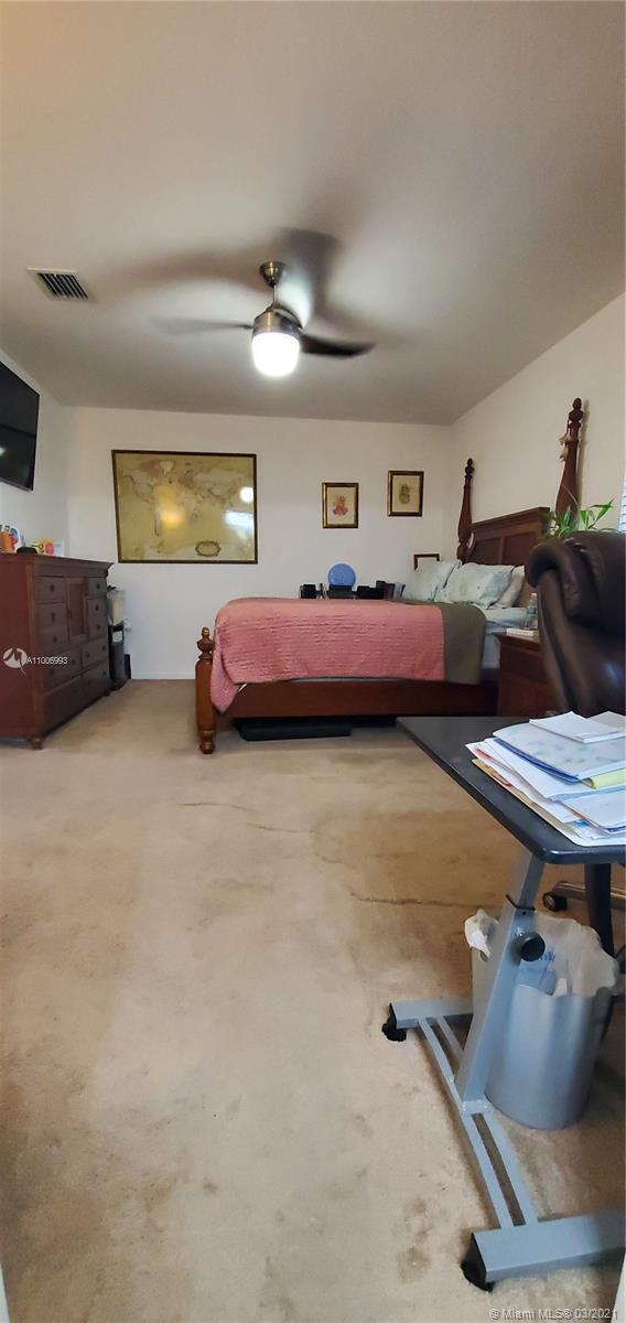 14140 Southwest 275th Street, Unit 1 Homestead, FL 33032 - Photo 14 of 25 a bedroom with furniture and a lamp