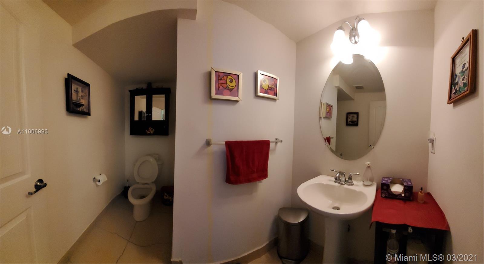 14140 Southwest 275th Street, Unit 1 Homestead, FL 33032 - Photo 18 of 25 a bathroom with a toilet sink and mirror