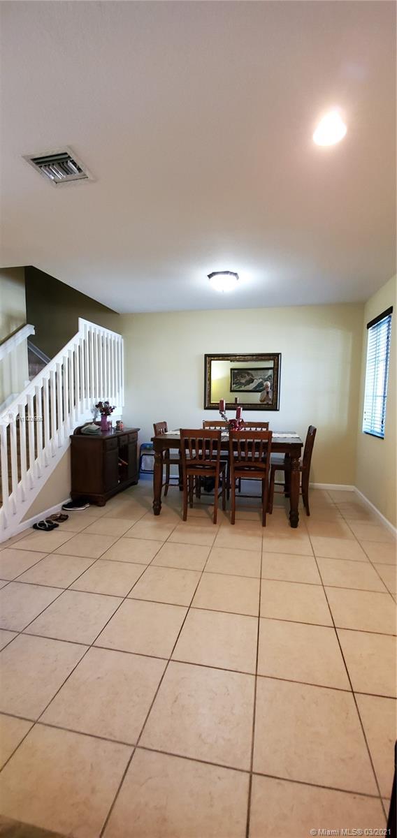14140 Southwest 275th Street, Unit 1 Homestead, FL 33032 - Photo 3 of 25 a living room with furniture and a dining table with projector