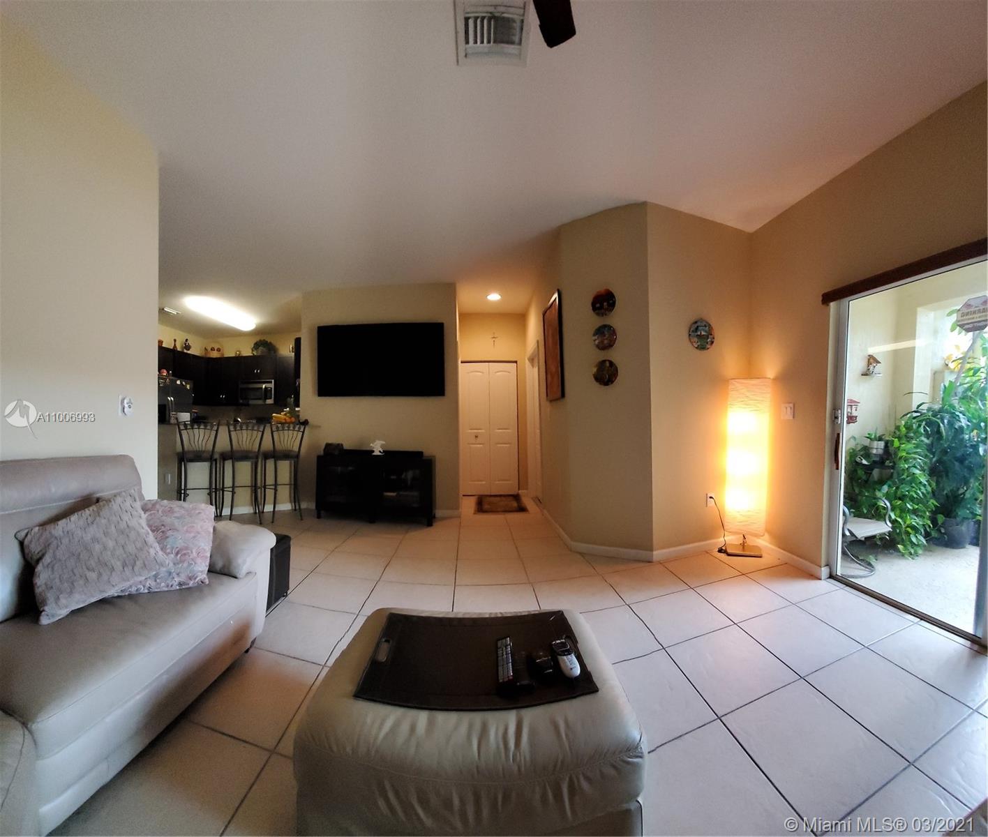 14140 Southwest 275th Street, Unit 1 Homestead, FL 33032 - Photo 4 of 25 a living room with furniture and a flat screen tv