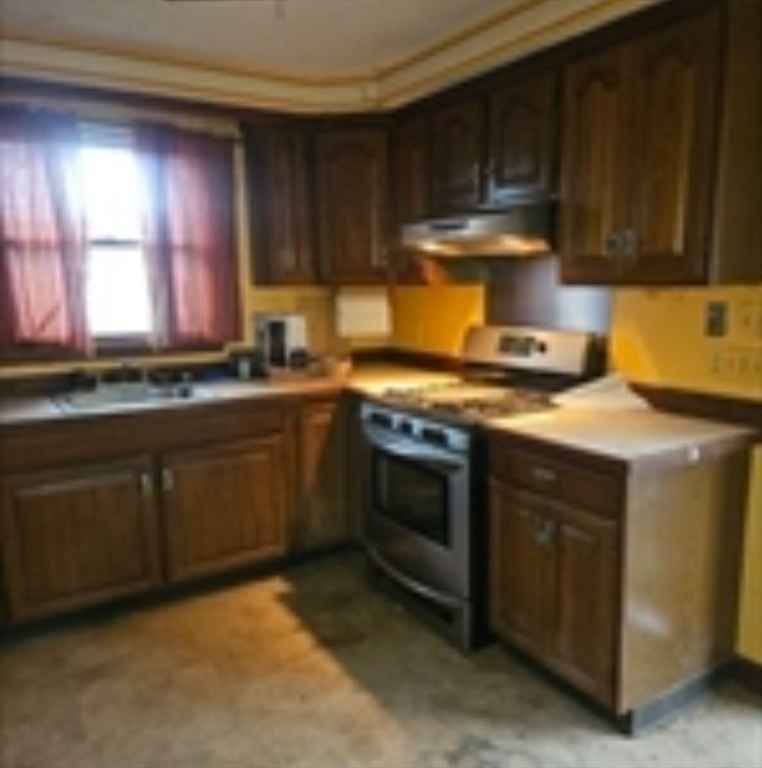 664 Norman Street Fall River, MA 02721 - Photo 8 of 12 a kitchen with a stove sink and cabinets