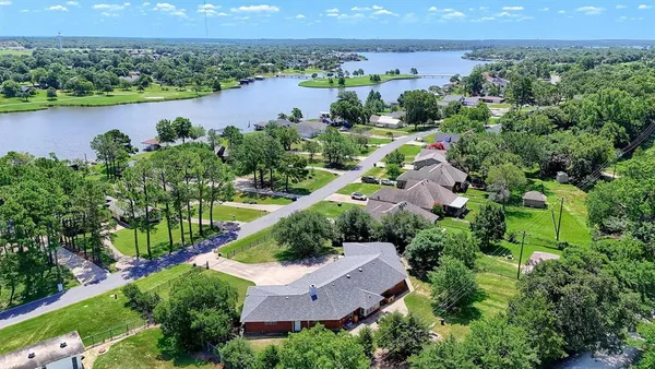 an aerial view of a house with a garden and lake view