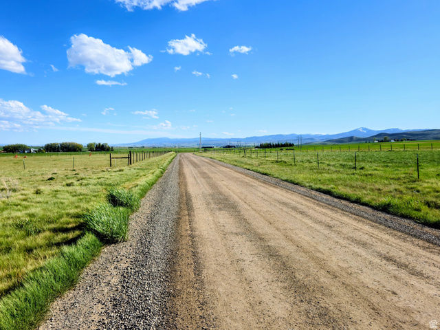 1720 Lower Bern Road, Unit 8 Bern, ID 83220 - Photo 2 of 7 Expansive rural property featuring a gravel road, green pastures, and distant mountain peaks