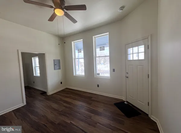a view of empty room with wooden floor and window
