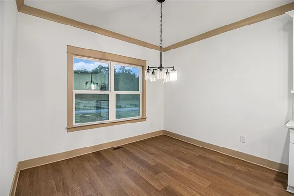 a view of empty room with wooden floor and window