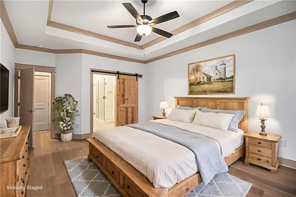 a spacious bedroom with a bed a dresser and potted plant