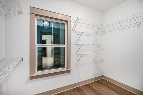 a view of a small space with wooden floor and a window