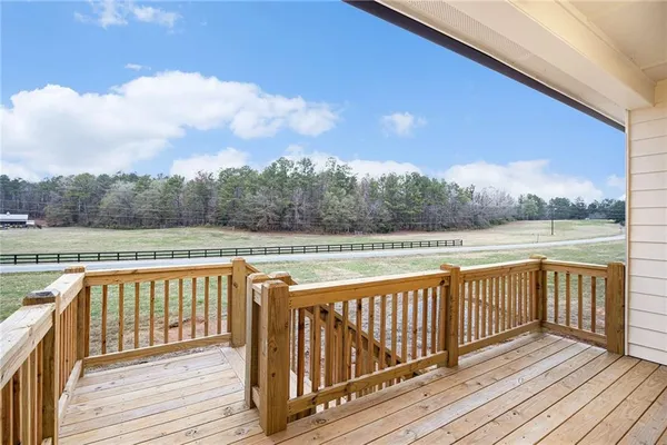 a view of a balcony with wooden floor and fence
