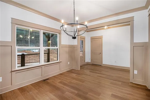a view of empty room with wooden floor and windows