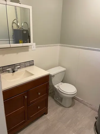 a bathroom with a toilet a sink and mirror