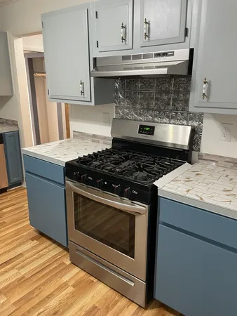 a stove top oven sitting inside of a kitchen