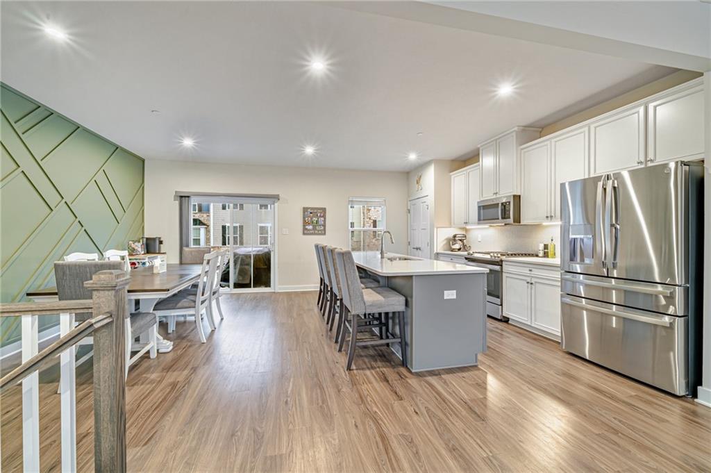 4200 Spruce Road Gibsonia, PA 15044 - Photo 5 of 31 a kitchen with stainless steel appliances a refrigerator a stove a sink dishwasher and a dining table with wooden floor
