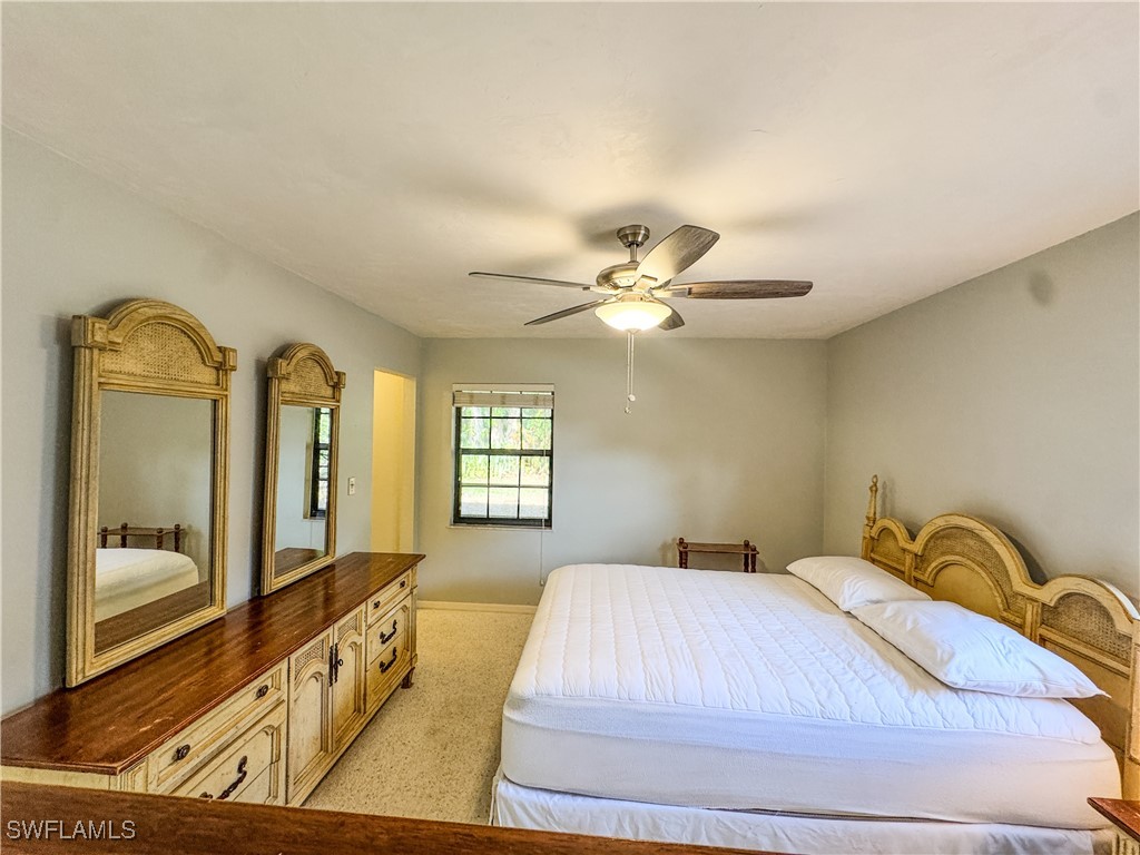 75 Hardee Street LaBelle, FL 33935 - Photo 15 of 24 a spacious bedroom with a bed mirror and window